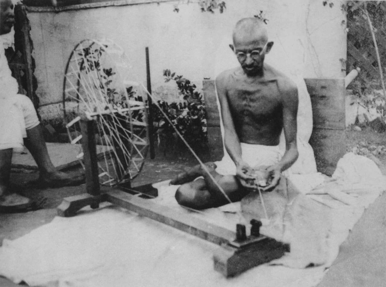 Mahatma Gandhi spinning the charkha.